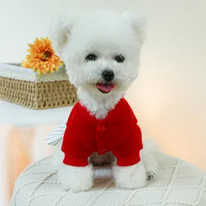 Cardigan festivo rosso con bottoni per cani di piccola taglia su un Bichon Frise bianco