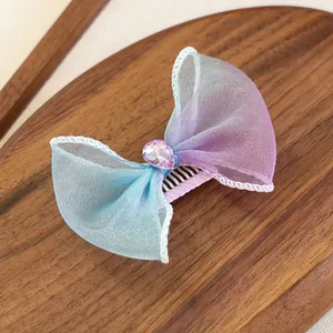Vue détaillée d'une barrette noeud en maille dégradée avec une gemme coeur rose