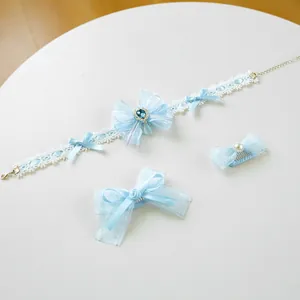 Detail of light blue pet lace collar and bow hair clips set with blue gemstone charm