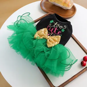 Detail of pet tutu dress with green tulle skirt and gold sequin bow on wooden tray