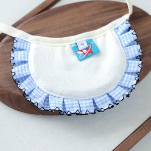 Detail of blue plaid pet bib with white textured fabric and red cartoon animal label