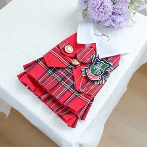Détail de la robe écossaise rouge pour chien avec badge brodé et boutons dorés