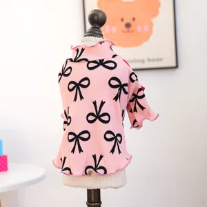 Detailed view of pink pet knit shirt with black bow patterns and ruffled edges