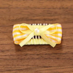 Gros plan d'un nœud papillon à rayures jaunes avec une perle pour cheveux d'animaux