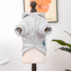 Détail macro du sweat à capuche tricoté pour animaux avec trois boutons gris