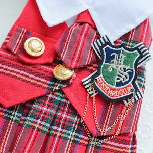 Détail de l'uniforme scolaire pour animaux avec motif écossais rouge et badge écusson
