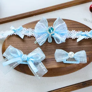 Close-up of light blue pet accessories set featuring lace bows, pearls and gems detail