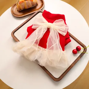 Dettaglio dell'abito festivo rosso per animali con fiocco in tulle e perle