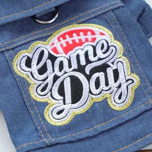 Detailed macro view of the Game Day embroidery and metal D-ring on the denim dog vest