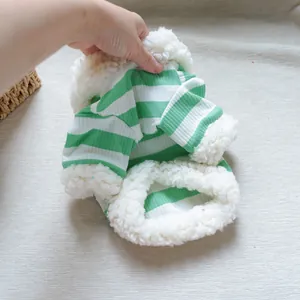 Detail of pet hoodie showing green striped knit fabric and thick white fleece lining