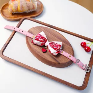 Détail du collier rose pour chat et chien avec nœud rouge et pendentif en cœur