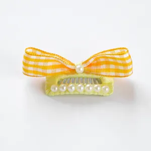 Detail van geel geruite haarstrik voor huisdieren met witte parels voor kleine honden