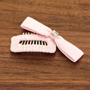 Gros plan du peigne à cheveux avec nœud rose et strass sur fond de bois foncé