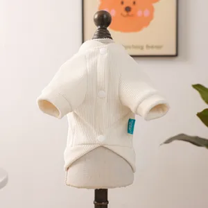 Detail of off-white ribbed pet sweater featuring three buttons and a brand label on back