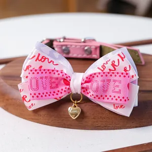 Gros plan du collier rose pour animaux avec nœud multicouche et pendentif cœur