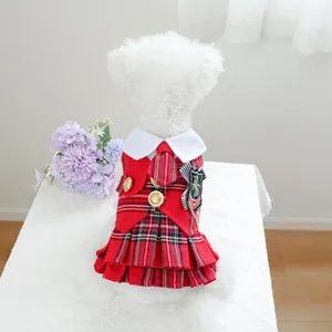 Détails d'une robe à carreaux pour animaux avec jupe plissée et badge style anglais