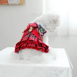 Détail d'une robe pour chien à carreaux rouges avec col blanc et boutons dorés