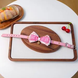 Gros plan du collier rose pour animaux avec nœud Love et pendentif cœur doré