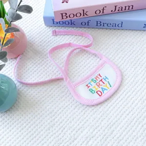 Close-up of birthday pet bib with colorful embroidery on soft waffle fabric background