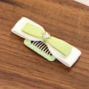 Détail d'un nœud papillon bicolore pour chien avec strass cœur sur fond en bois
