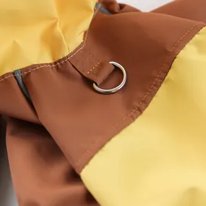 Detail of waterproof dog raincoat featuring reinforced D-ring and reflective safety strip