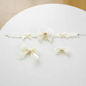 Detailed view of lace pet bow collar with heart gemstone and matching hair clips