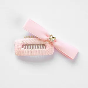 Detail van roze strik haarclip voor huisdieren met een sprankelende kristallen vlinder