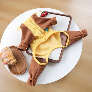 Flat lay of a waterproof pet raincoat with yellow and brown contrast on a white table