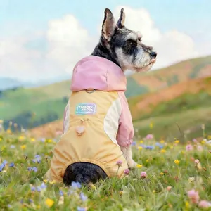 Detail of pink and yellow pet raincoat featuring Happy Faces patch and leash D-ring attachment