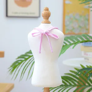 Detailed view of pink and white striped pet bib with bow tie on white mannequin