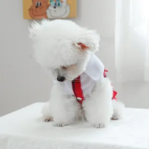 Détail d'une chemise blanche pour animaux avec col écossais rouge et boutons