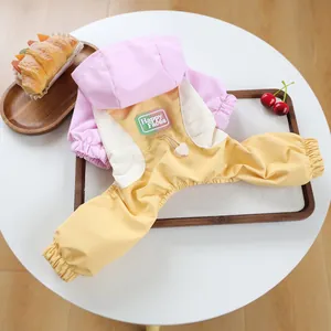 Close-up of pink and yellow pet raincoat with Happy Faces patch on wooden tray