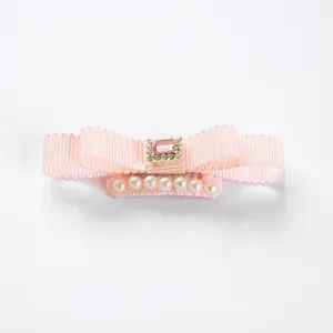 Detail van roze strik haarclip voor huisdieren met kristal en imitatieparels