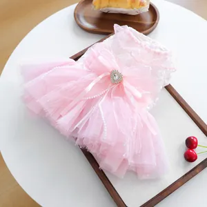 Detail of pink pet wedding dress with lace embroidery, tulle layers and rhinestone bow