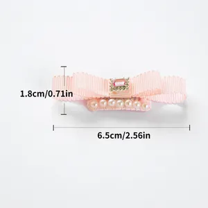 Pink ribbon dog hair clip with faux gemstone and pearls measuring 6.5cm in width