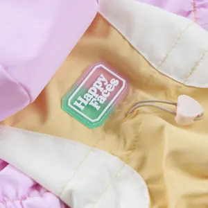 Detail of pink and yellow dog raincoat with Happy Faces badge and heart drawstring