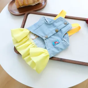 Detail of pet denim dress with yellow pleated skirt and bronze buttons for small dogs