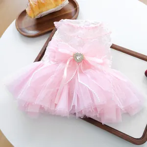 Detailed view of pink pet wedding dress featuring lace trim and heart rhinestone bow