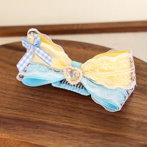 Détail macro d'un nœud papillon pour chien avec dentelle, rubans et gemme en cœur