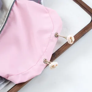 Close-up of pink pet windbreaker with adjustable drawstring and metal eyelets