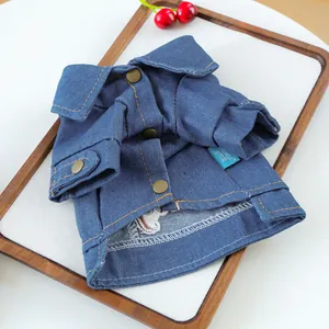 Close-up of denim pet shirt featuring classic bronze buttons and orange contrast stitching