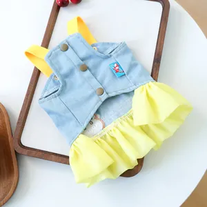 Detail of pet denim dress showing yellow strap buttons and layered chiffon skirt ruffle