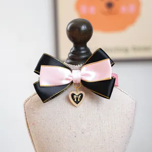 Détail d'un nœud pour animal avec pendentif cœur et perles sur un petit support