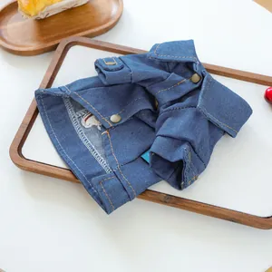 Close-up of deep blue denim pet jacket with metallic buttons and colorful embroidery