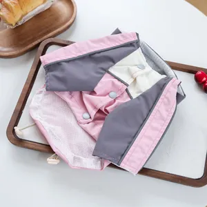 Detail of pink and grey pet windbreaker featuring breathable white mesh lining and snaps