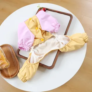 Detail of pink and yellow pet jumpsuit showing breathable white mesh lining and snap buttons