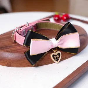 Détail du collier rose pour chat avec grand nœud en satin et pendentif cœur perlé