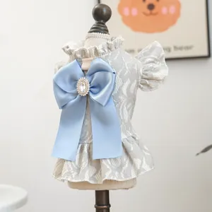Detail of pet dress featuring grey lace floral texture and blue satin bow with gemstone