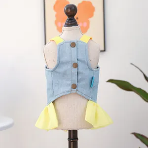 Detail view of denim pet dress featuring yellow straps and decorative brown buttons