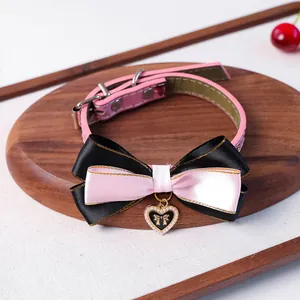 Détail du collier pour animaux en cuir rose avec nœud satiné et pendentif cœur doré